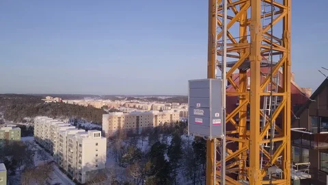 4K Aerial Footage of an elevator on a tower crane rising over new construction Video stock 93142456