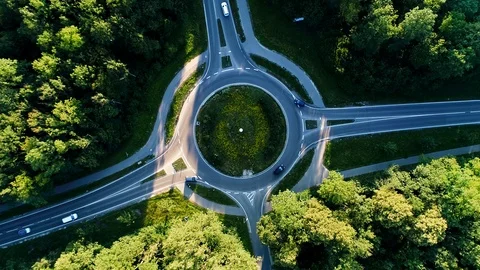 4K aerial footage of roundabout and street with cars and trucks driving through Stock Footage