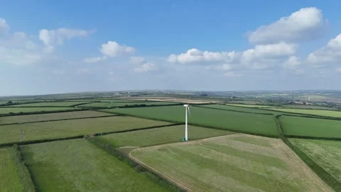 4K Aerial Footage of a Working Wind Turbine in Rural Fields Stock Footage 276908046
