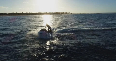 4K aerial front view of man having fun riding a Jet Ski in the ocean with the Stock Footage 102769498
