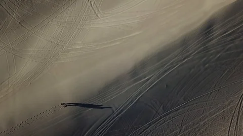 4K Aerial High Angle View of Hikers Walking on Immaculate Sand Dunes Stock Footage 129515311