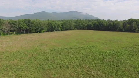 4K aerial of mountain in clouds with a field 스톡 동영상 56676814