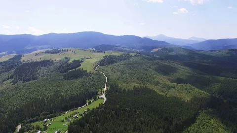 4K .Aerial  mountain landscape. Fly over hills with wood and village in rural ar Vídeo Stock 80305731