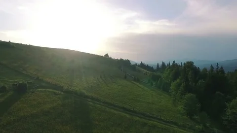 4K .Aerial  mountain landscape. Fly up over meadow among hills, sunrise time Stockbeeldmateriaal 80331060