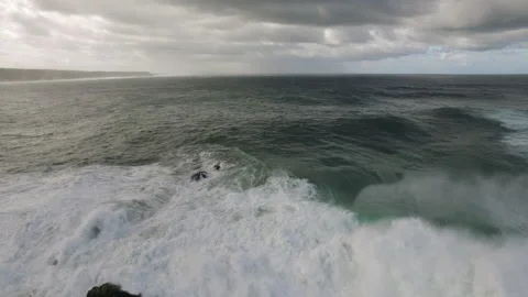 4K Aerial of ocean waves foaming up from surface as wind picks up on cloudy day Stock Footage 156087665