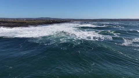 4K Aerial Ocean Waves Rolling Toward Rocky Coastline Stock-Footage 333704099