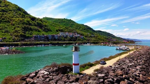 4K Aerial Orbit Around White Lighthouse Over Coastal Marina and Forest Holiday Vídeo Stock 337815799
