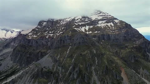 4K Aerial Orbit View of Snow Patched Stroggoula Mountain Peak Cliff Stock Footage 335179433