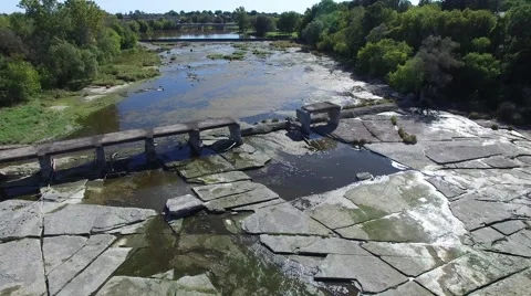 4k aerial over river bed and crumbled train bridge Stock Footage 55607199