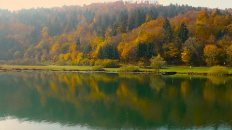4K Aerial: Passing Vibrant Fall Forest and Lake Vídeo Stock 56933378