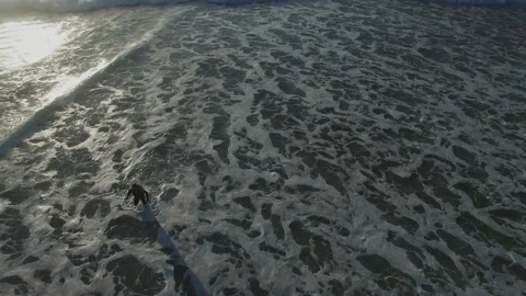 4K aerial of pro surfer getting out of sea to sunny beach of Portugal coast Stock Footage 159841981