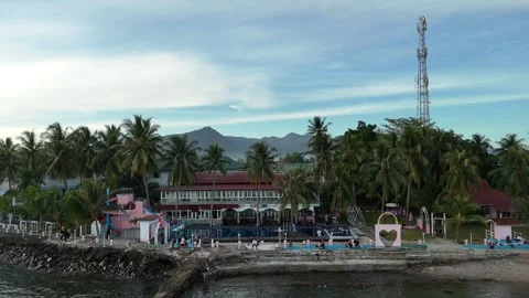 4K Aerial Pull Back of Tropical Beach Resort with Mountain Background in Indones Stock Footage 331488073