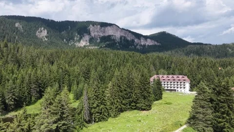4K Aerial Pull Out Shot of Mountain Hotel and Forest Landscape Stock Footage 345563618
