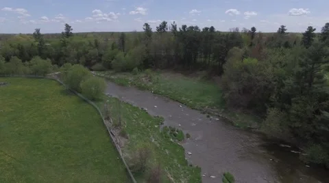 4k aerial rotating view of meadows and stream Stock Footage 64212292