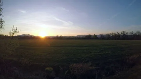 4K: Aerial shot of a beautiful sun setting over green meadow Stock Footage 74883853