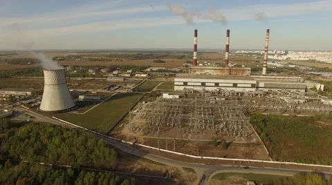 4K aerial shot – flight over power plant with smoking pipes and a city near Stock Footage 56161953