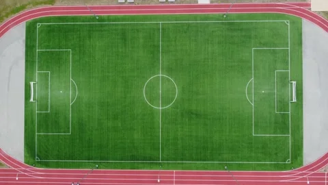 4k aerial top view of empty soccer field with running tracks - zoom in to the ce Stock Footage 245718199