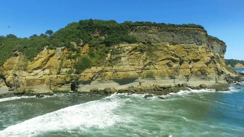 4k Aerial tracking shot looking waves crashing on cliffs in the Pacific Ocean 動画素材 90959323