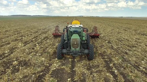 4K Aerial Of Tractor Pulling Disc Seeder Front On Then Rotate To Side Shot Stock Footage 83607745