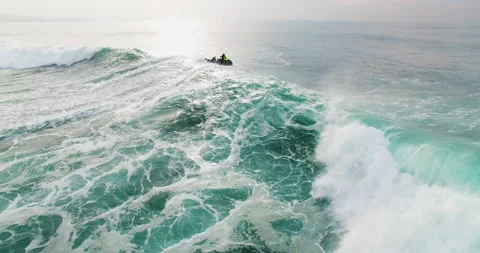 4K aerial of two people pulling surfer on rescue sled behind jet ski Video stock 160498111