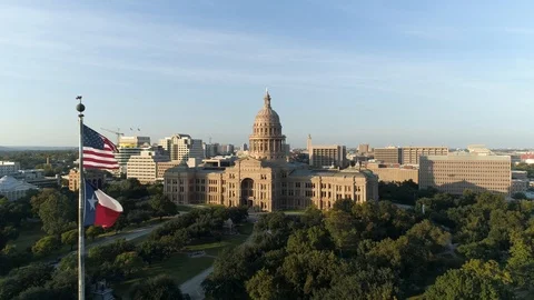 4K Aerial US And Texas Flags Flying Texas State Capitol Building Austin Sunset Stock Footage 97863853