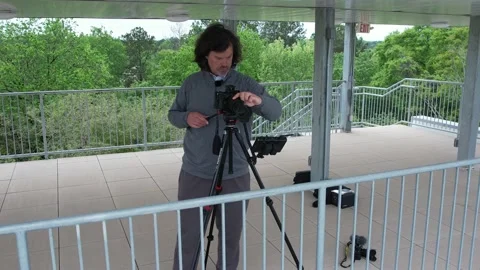 4K aerial of a videographer camera operator setting up a livestream Stock Footage 218369084