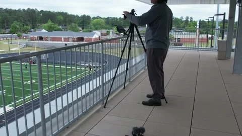 4K aerial of a videographer camera operator setting up a livestream Stock Footage 218369099