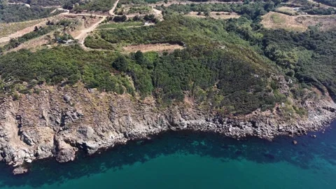 4K Aerial View Approaching Rocky Coastline and Turquoise Sea Cliffs Stock Footage 341531895
