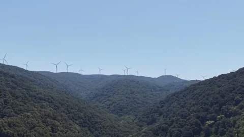 4K Aerial View Approaching Wind Turbines on Mountain Ridge Above Green Valley Stock Footage 341531754