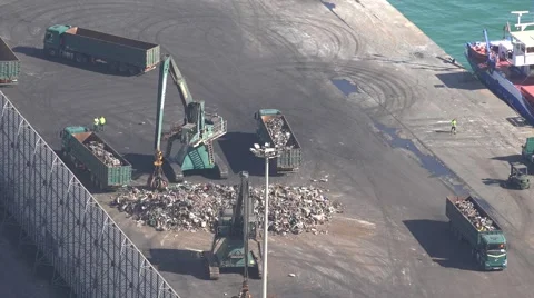 4K Aerial view crane machine load truck trailer scrap iron trash seaport port  Stock Footage 54428418