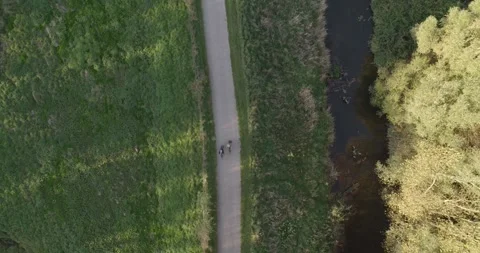 4K Aerial View of Cyclists on a Pathway at Sunset Stock Footage 245442123