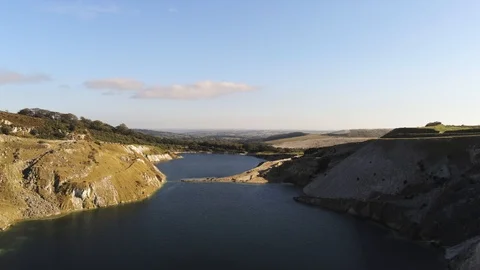 4K Aerial View Descending Into Quarry Lake on Sunny Day Stock Footage