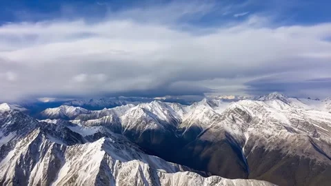 4K Aerial View Dramatic Snow Capped Mountain Range Partly Cloudy Sky Stock-Footage 334449051