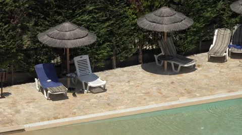 4K Aerial view empty sunbed and straw umbrella near pool water in Corfu island  Stock Footage 65824060