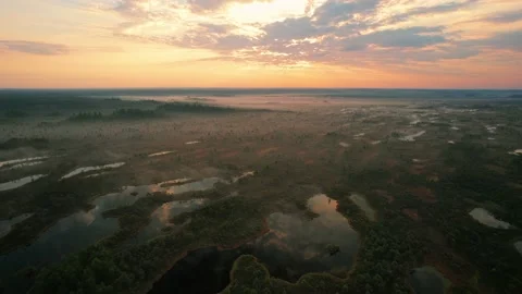 4k aerial view of endless forests and lakes, orange sky and reflection in lakes Stock-Footage 160680881