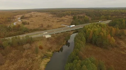 4K aerial view – flight over highway with river and colorful autumn forests Stock Footage 56165327