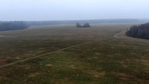 4K aerial view flight over the beveled field in autumn in a strong fog Video stock 121754059