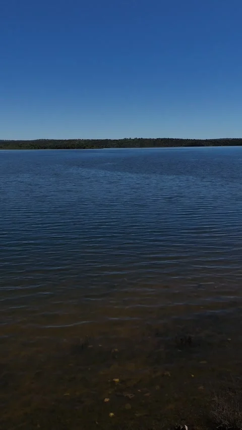 4K Aerial view flying forward over a fisherman casting his rod into a lake Stock Footage 336205443