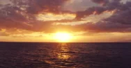 4K Aerial View Flying Low Over Ocean Into Dramatic Vibrant Sunset. Stock Footage