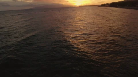 4K Aerial View: Flying Low Over Pacific Ocean at Sunset  Tilting Up Motion Stock Footage 65781864