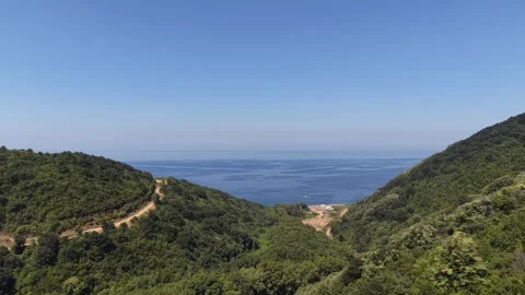 4K Aerial View Flying Through Forested Valley toward Blue Ocean and Horizon Stock Footage 341531668