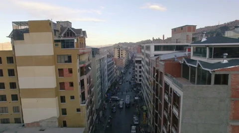 4K aerial view forward above buildings street traffic la paz bolivia Видео 64785627
