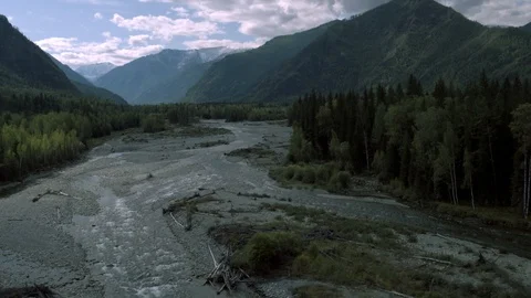 4K aerial view. Low flight over a cold mountain river Mountains trees and sky Stock Footage 123129098
