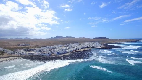 4K Aerial view of ocean waves in sunny Lanzarote - Famara Surf Village Stock Footage 123469981