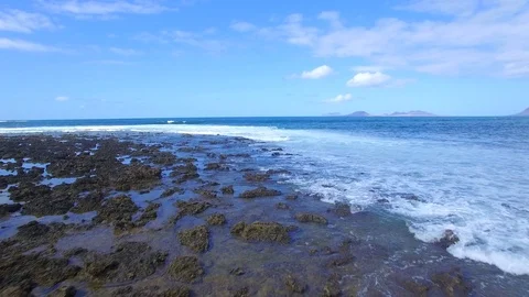4K Aerial view of ocean waves in sunny Lanzarote - Famara Village Stock Footage 123470051
