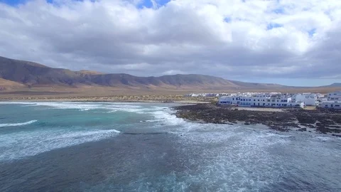 4K Aerial view of ocean waves in sunny Lanzarote - Famara Village Video stock 123470064
