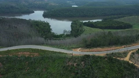 4k aerial view of a road between the hills and near a lake in Brazil Stock Footage 239245873