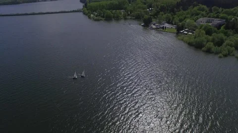 4K aerial view of sailing boats on a sunny lake with reflections on the water Stock Footage