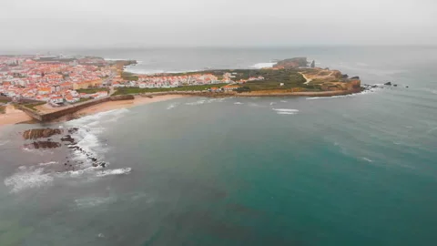 4k Aerial view of sea waves break on yellow sand beach Peniche, Portugal Stock Footage 139348549
