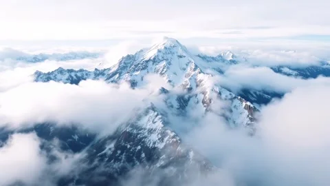 4K Aerial View Snow Covered Mountain Peak Above Stratocumulus Clouds Vídeos de archivo 334449426